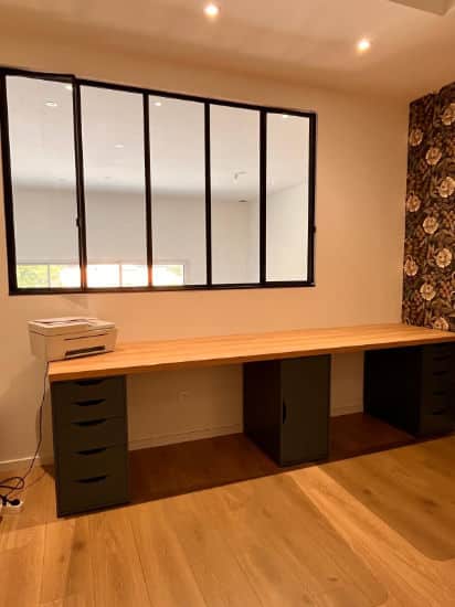 Vue sur une verriere métallique séparant un bureau d'une pièce à vivre